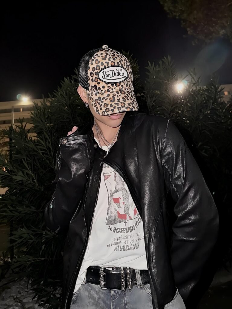 FELIP wearing a white top and black leather jacket styled with a Von Dutch Vanimal trucker cap